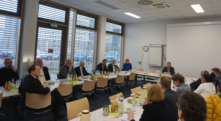 Teilnehmer des Neujahrsdialogs des Beauftragten der Sächsischen Staatsregierung für die Belange von Menschen mit Behinderungen sitzen an Tischen