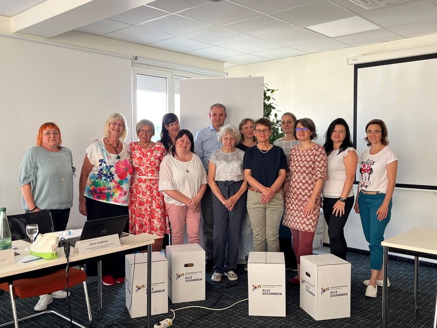 Die Teilnehmer der Klausurtagung stehen im Tagungsraum als Gruppe zusammen. 