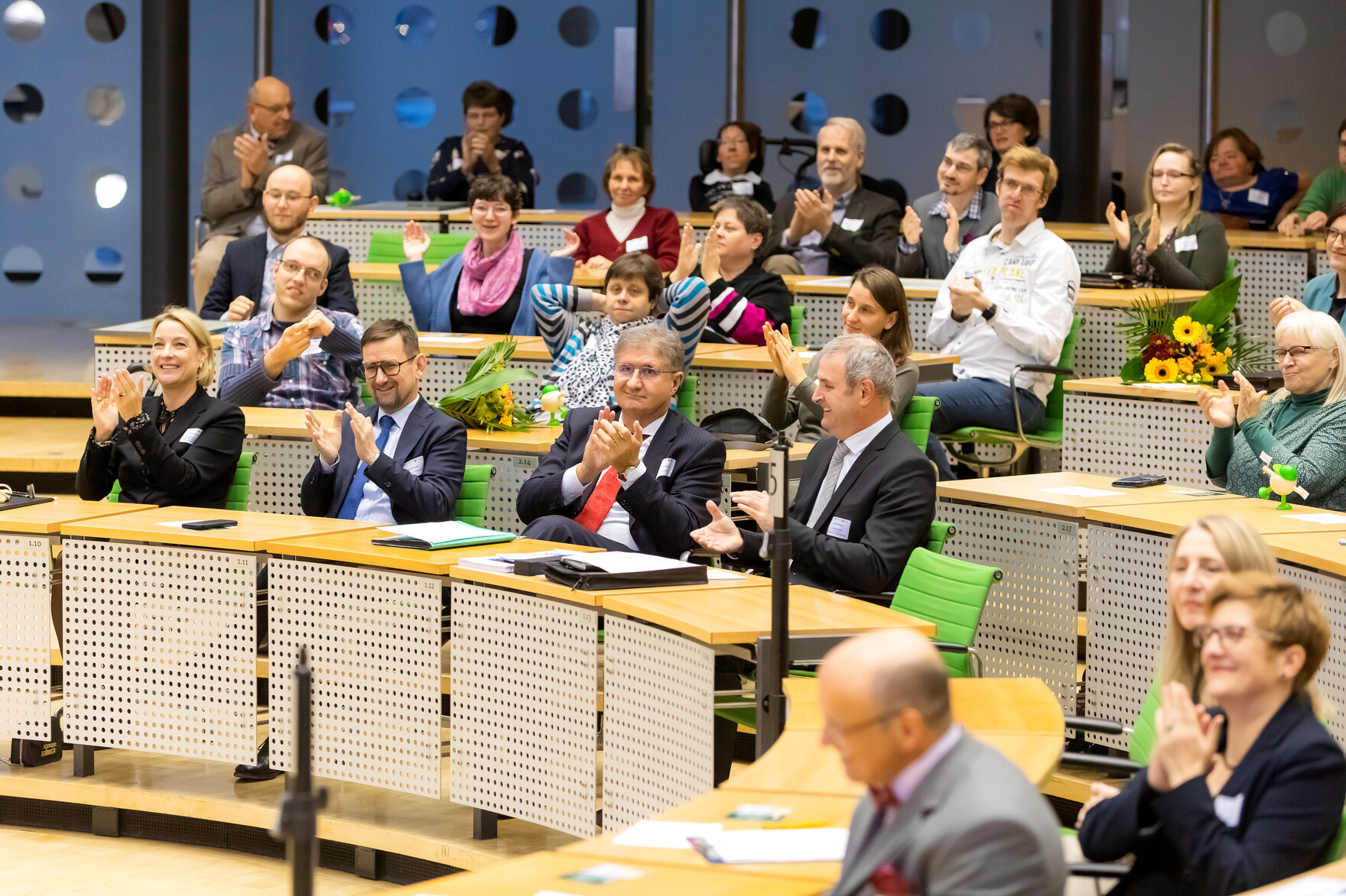 Momentaufnahme von einer Vielzahl an Teilnehmern der Preisverleihungsfeier vom 5. Sächsischen Inklusionspreis, die im Plenarsaal des Sächsischen Landtages sitzen und nach vorne auf das Präsidium schauen.