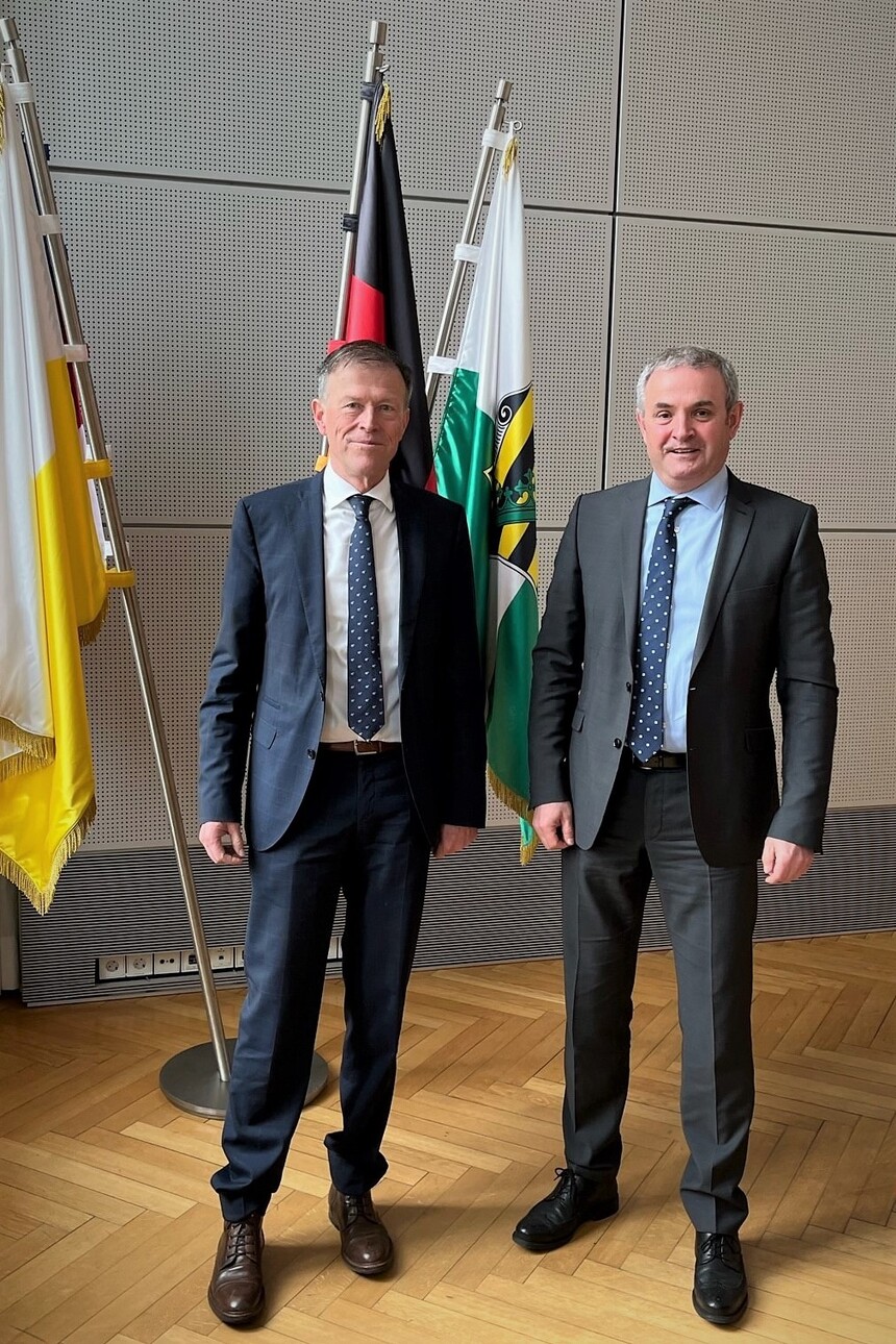 Der Präsident des Sächsichen Landtages, Dr. Matthias Rößler steht vor einer Wand mit drei Fahnen neben dem Inklusionsbeauftragten der Sächsischen Staatsregierung, Michael Welsch.